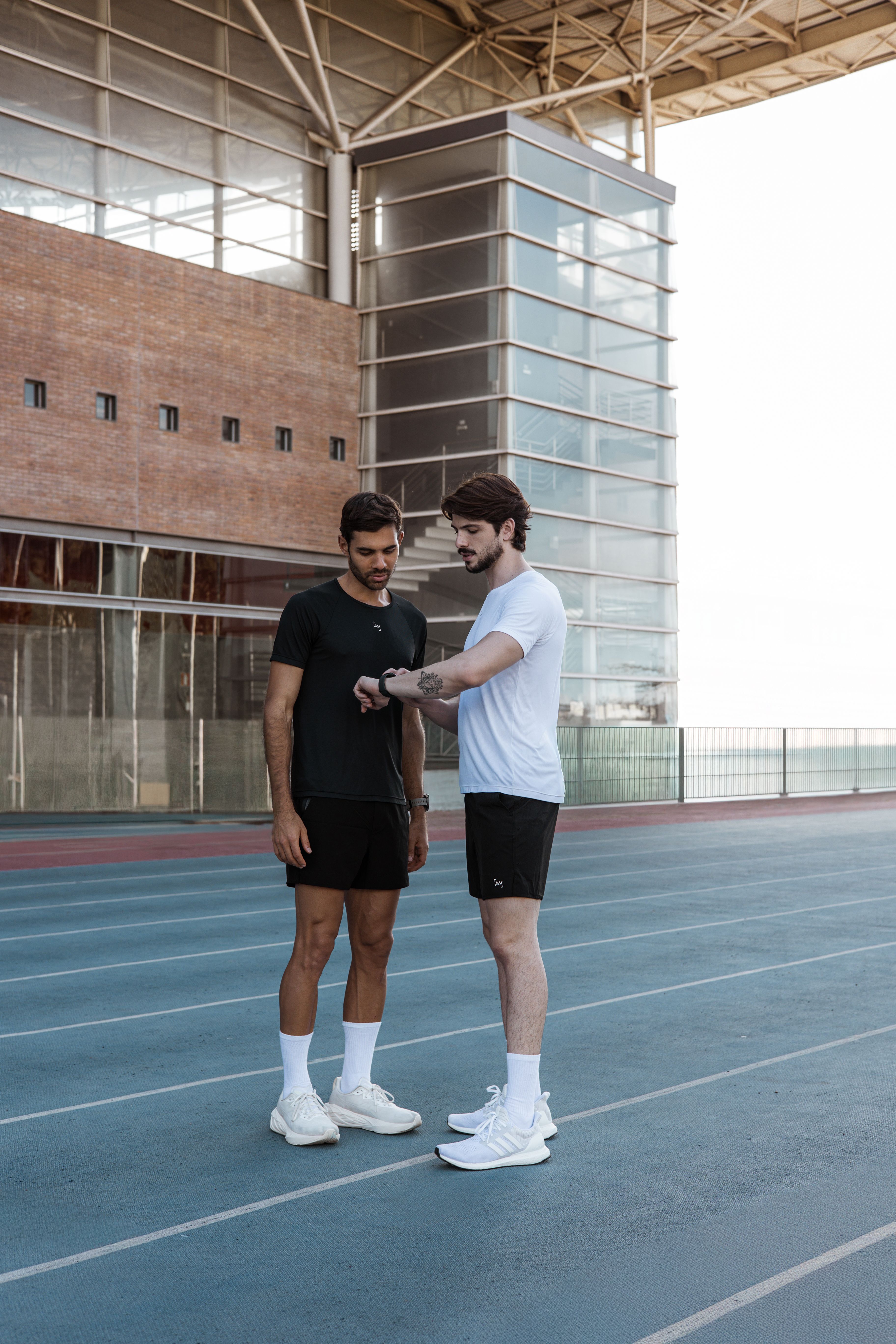 Two runners checking pace on a running track
