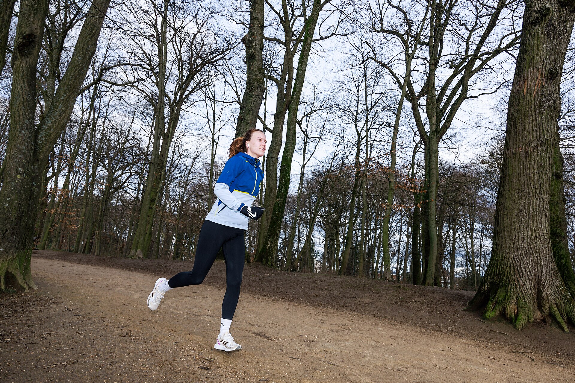 Woman running on a woodland path in a park